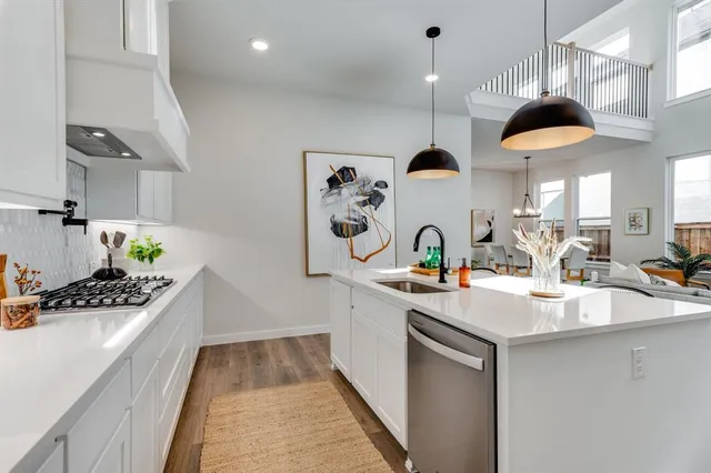 a kitchen with stainless steel appliances granite countertop a stove a sink and a cabinets