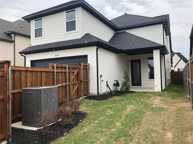 a view of a house with wooden fence and a large tree
