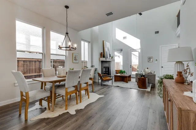a view of a dining room and livingroom with furniture wooden floor a chandelier