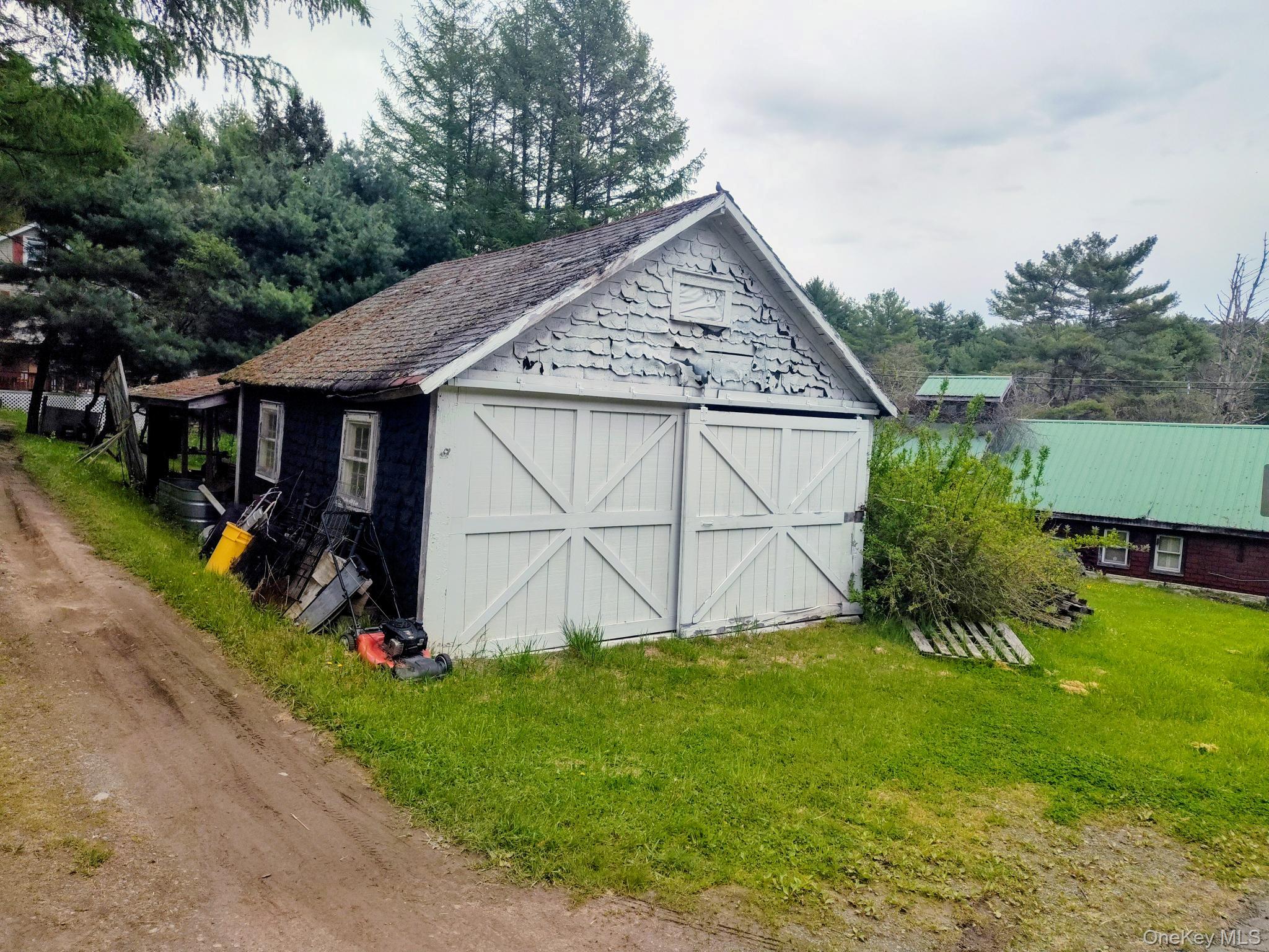 174 Forestburgh Road Forestburgh, NY 12777 - Photo 23 of 28 a view of a barn with a yard potted plants and a large tree