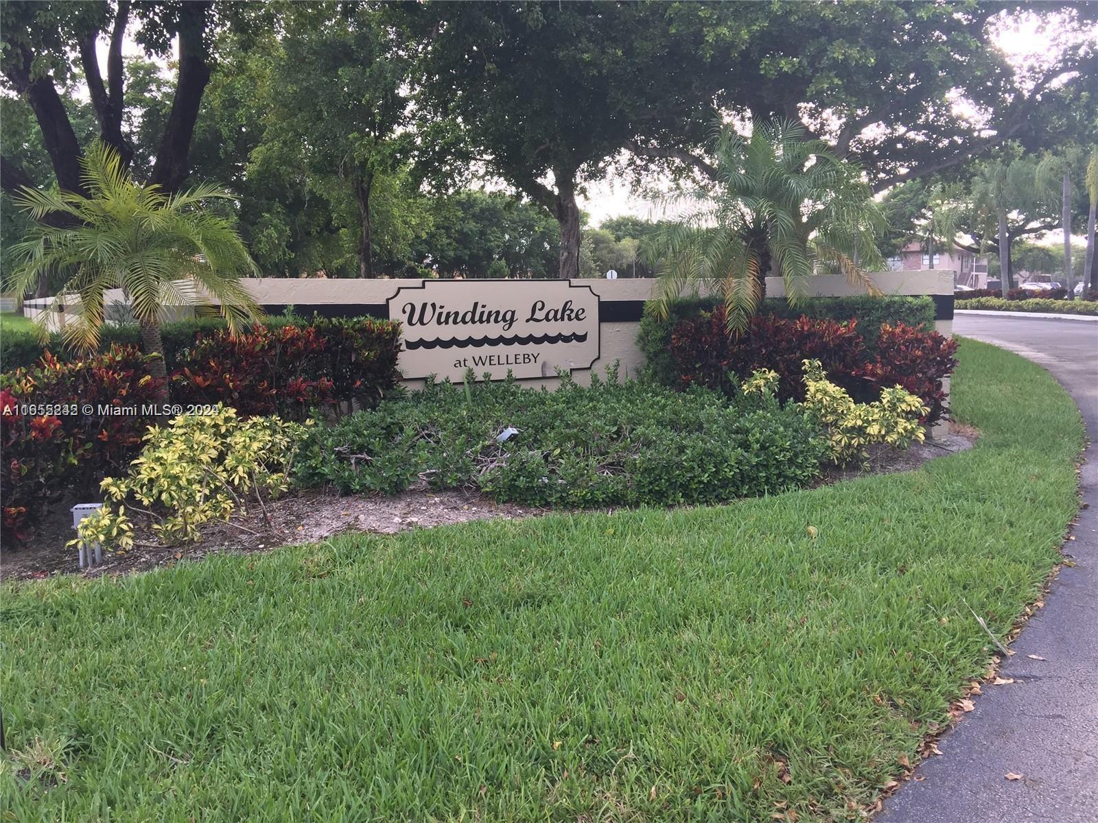 10057 Winding Lake Road, Unit 103 Sunrise, FL 33351 - Photo 1 of 13 a view of a park that has large trees