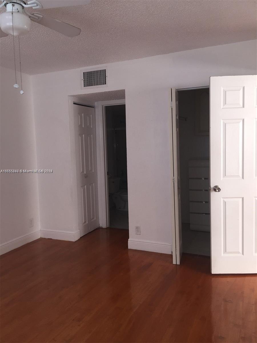 10057 Winding Lake Road, Unit 103 Sunrise, FL 33351 - Photo 11 of 13 an empty room with wooden floor