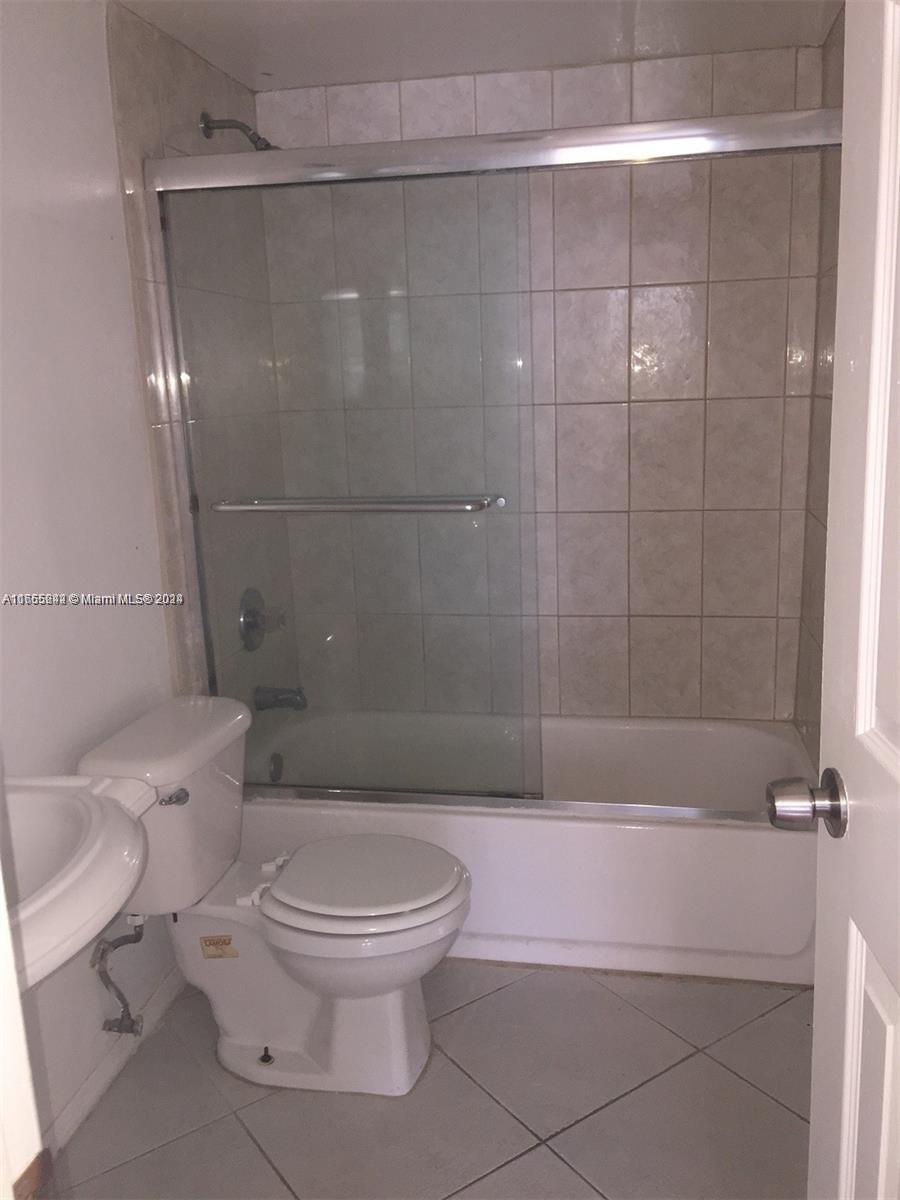 10057 Winding Lake Road, Unit 103 Sunrise, FL 33351 - Photo 8 of 13 a bathroom with a toilet and shower