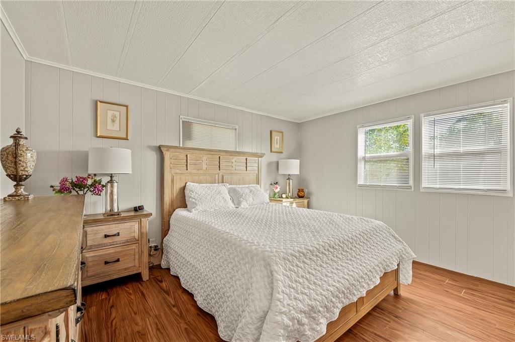 284 Cape Sable Drive Naples, FL 34104 - Photo 11 of 20 a bedroom with a bed and wooden floor