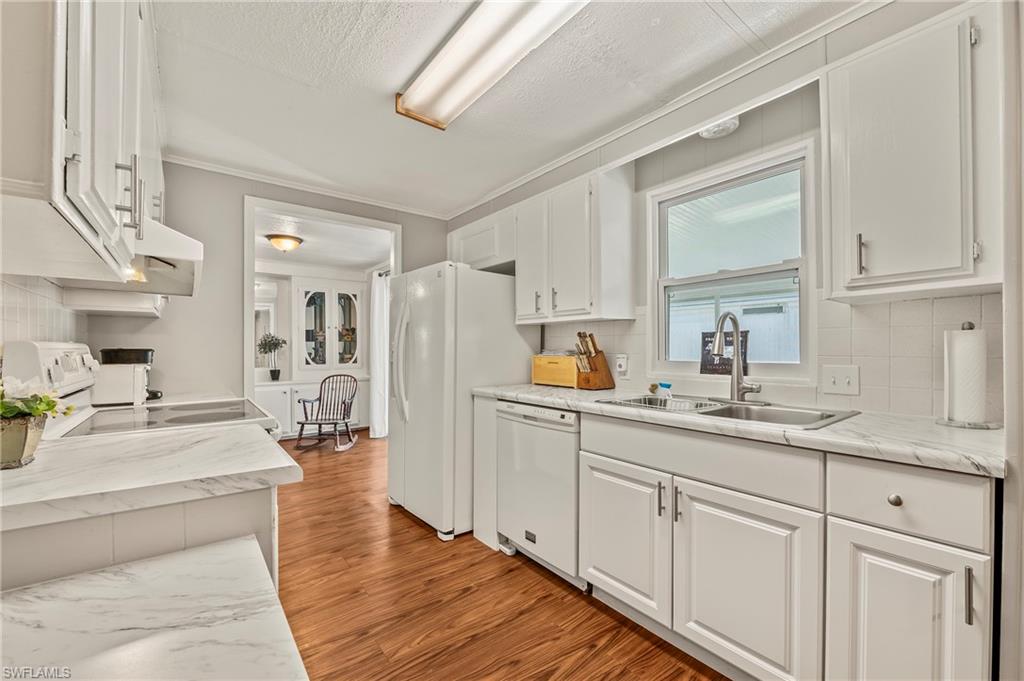 284 Cape Sable Drive Naples, FL 34104 - Photo 8 of 20 a kitchen with white cabinets and sink