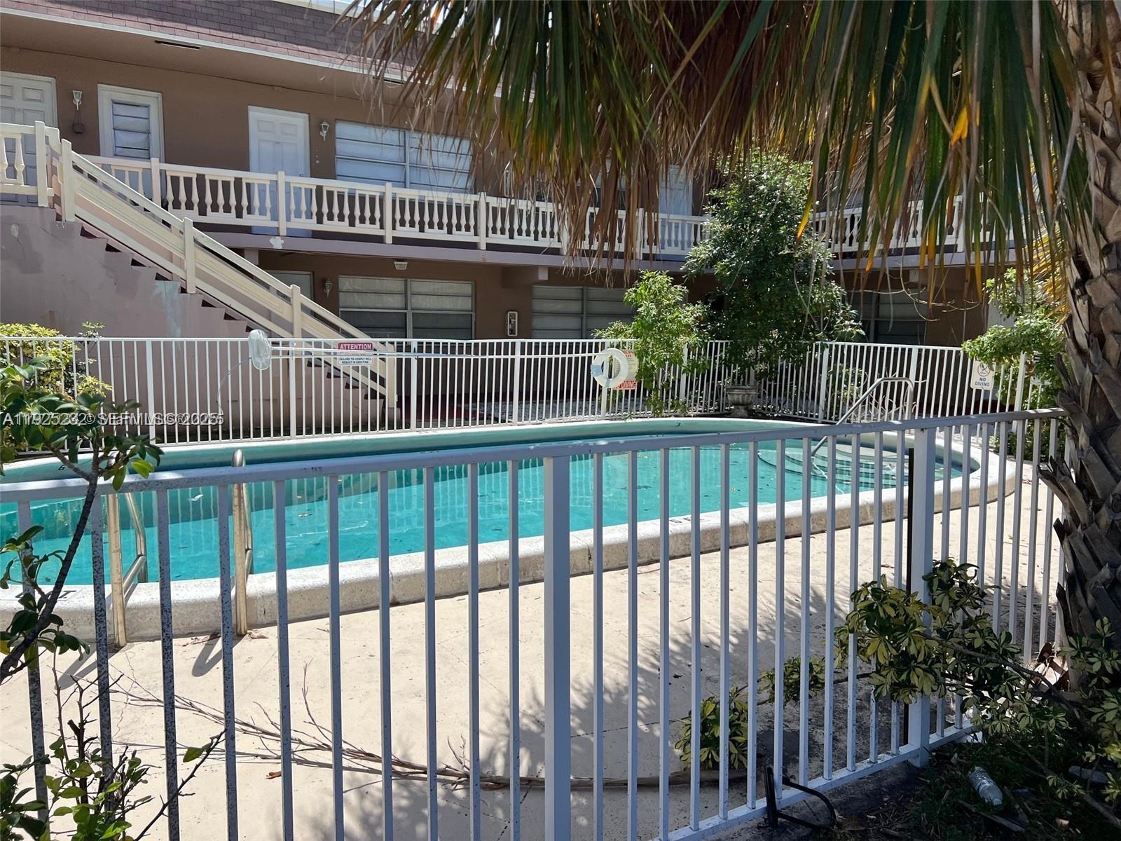 241 Southeast 9th Avenue, Unit 106 Pompano Beach, FL 33060 - Photo 11 of 19 a view of entryway with a small yard and wooden fence