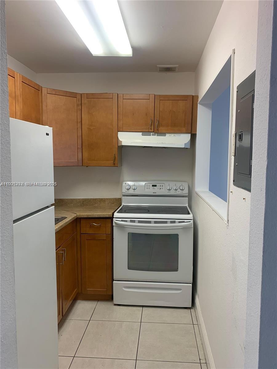 241 Southeast 9th Avenue, Unit 106 Pompano Beach, FL 33060 - Photo 3 of 19 a kitchen with a stove and a refrigerator