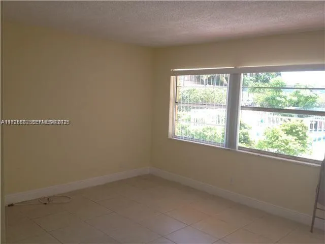 a living room with a floor to ceiling window and a potted plant