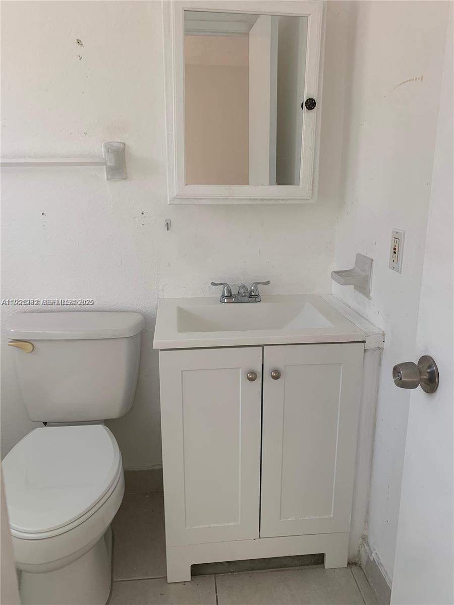 241 Southeast 9th Avenue, Unit 106 Pompano Beach, FL 33060 - Photo 8 of 19 a bathroom with a sink a toilet and mirror