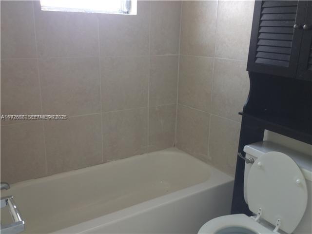 241 Southeast 9th Avenue, Unit 106 Pompano Beach, FL 33060 - Photo 9 of 19 a bathroom with a toilet and bathtub