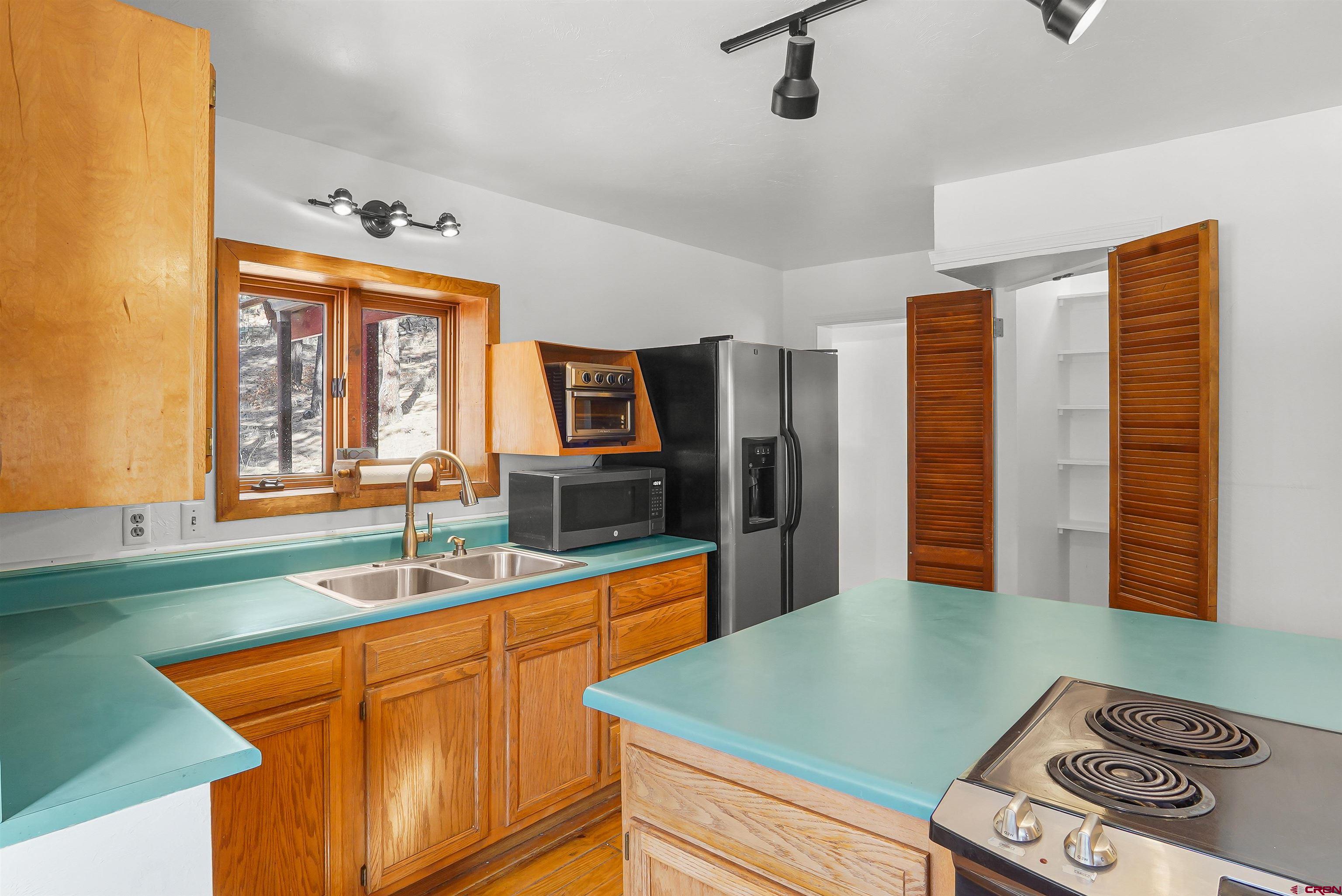 78 Groves Drive Durango, CO 81301 - Photo 14 of 35 a kitchen with stainless steel appliances granite countertop a sink and a wooden cabinets