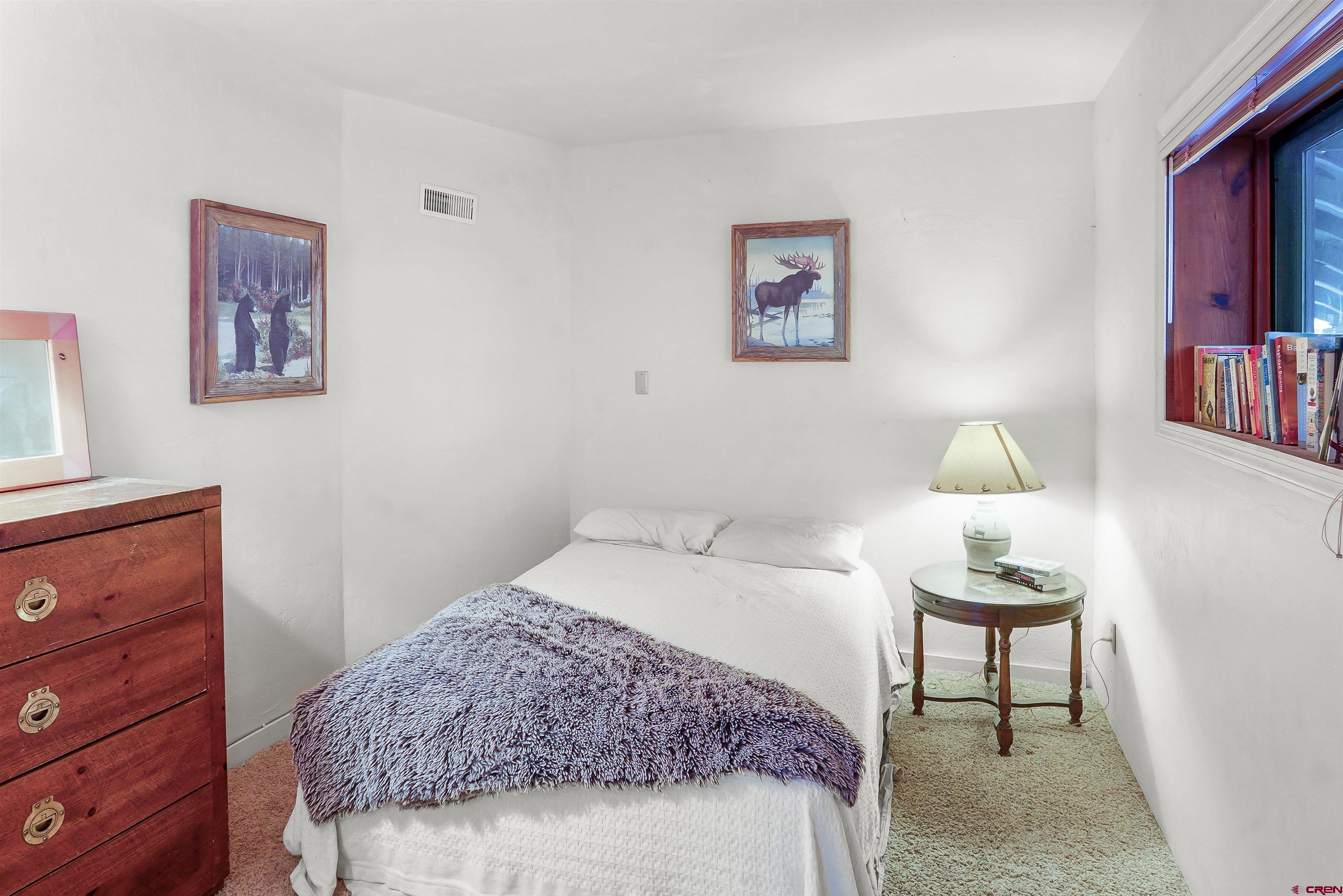78 Groves Drive Durango, CO 81301 - Photo 26 of 35 a bedroom with a bed and a lamp on dresser