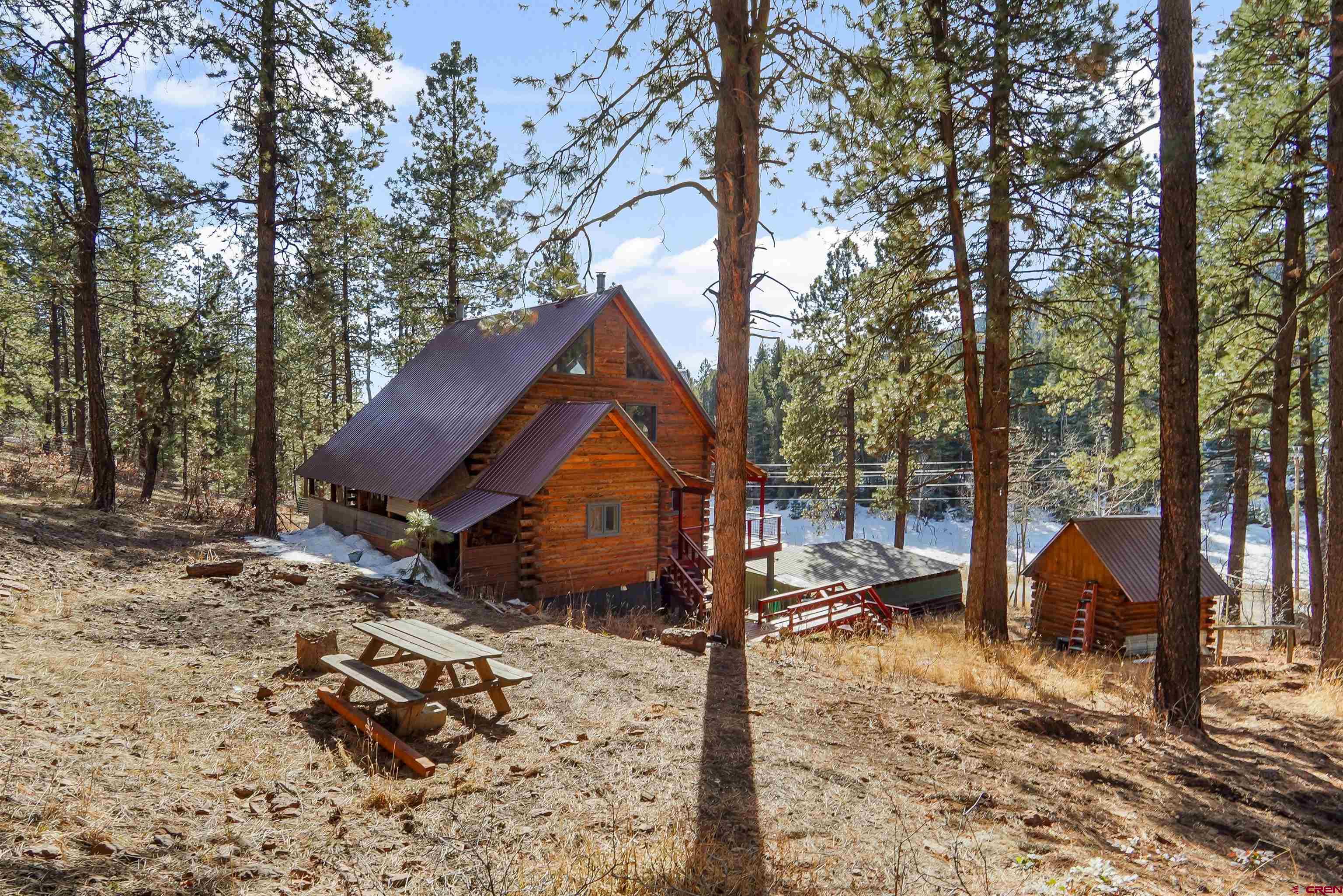 78 Groves Drive Durango, CO 81301 - Photo 30 of 35 a view of a wooden house with a yard covered in snow