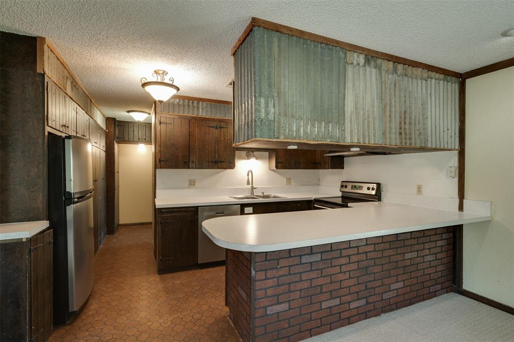 3377 Lodge Creek Road Henrietta, TX 76365 - Photo 10 of 40 a kitchen with stainless steel appliances granite countertop a sink a refrigerator and a stove