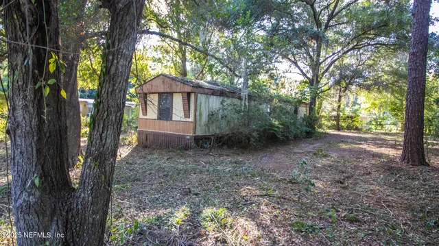 a view of a house with large trees and a barn