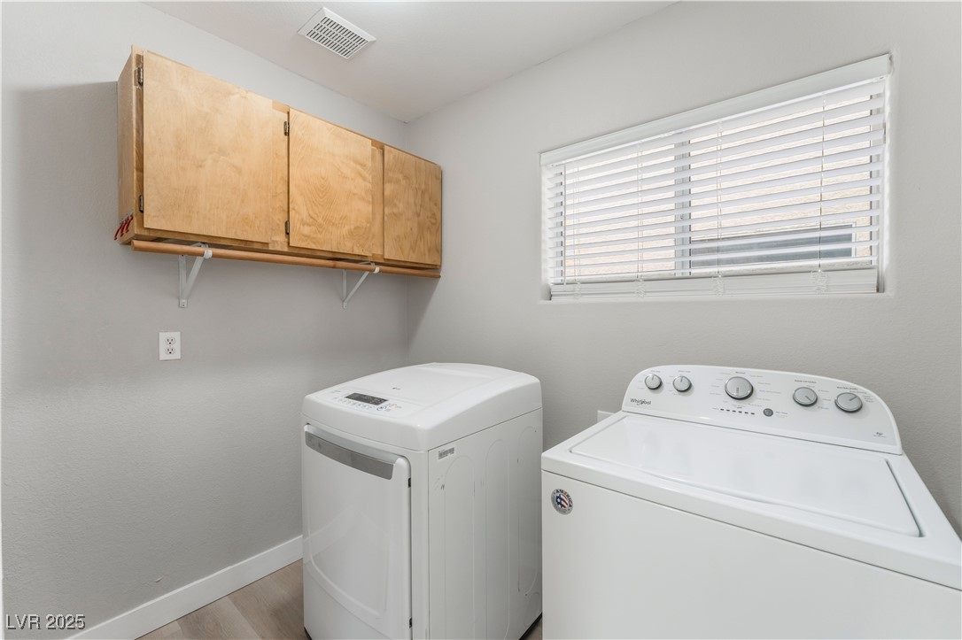 3695 Funston Way Las Vegas, NV 89129 - Photo 19 of 43 Washroom with washing machine and dryer, cabinet space, and light wood-style floors