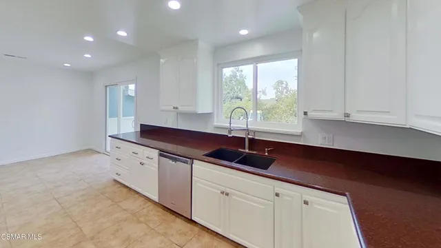 a kitchen with granite countertop white cabinets and a sink
