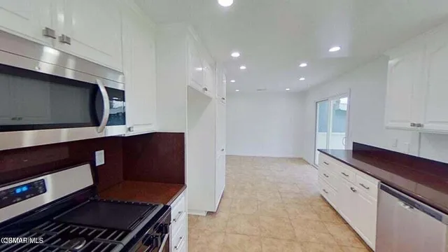 a kitchen with stainless steel appliances a microwave a stove and a sink