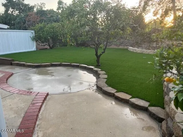 a view of a street with a yard and large trees