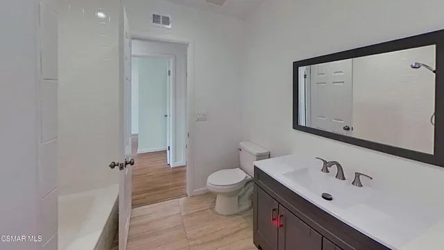 a bathroom with a sink a toilet and a large mirror