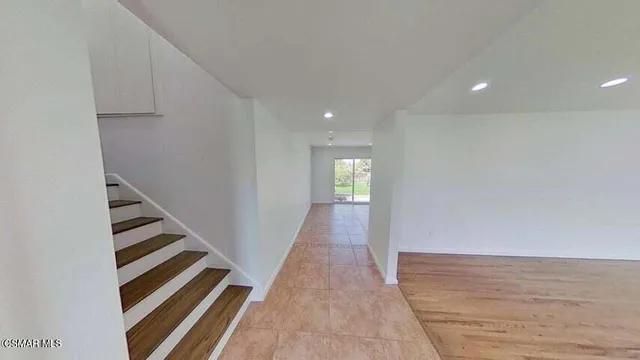 a view of a hallway with wooden floor and staircase