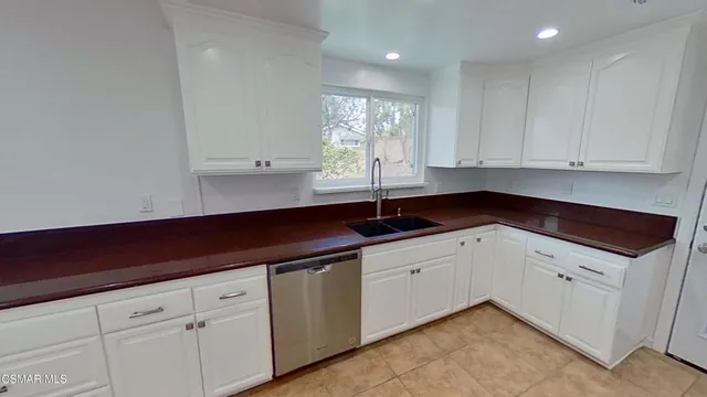a kitchen with granite countertop white cabinets and white appliances