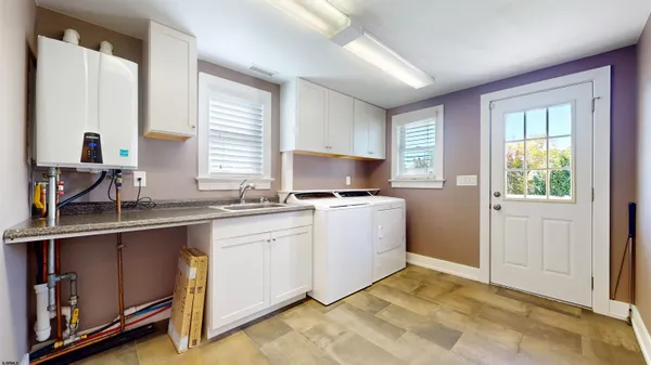 a kitchen with stainless steel appliances granite countertop a refrigerator a sink a stove a dining table and chairs