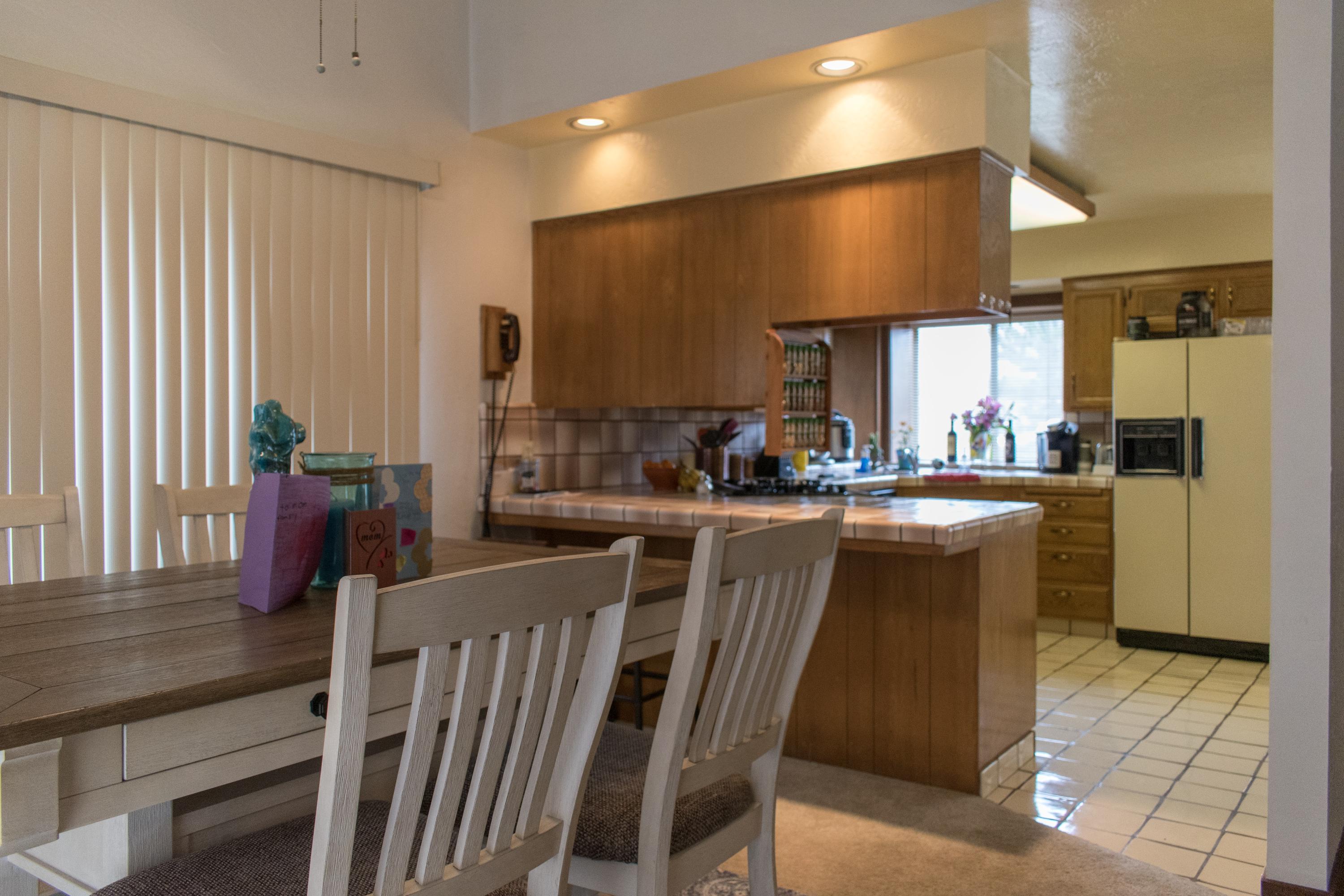 21175 Ridgeway Drive Tehachapi, CA 93561 - Photo 24 of 45 a kitchen with stainless steel appliances kitchen island granite countertop a table chairs and a refrigerator