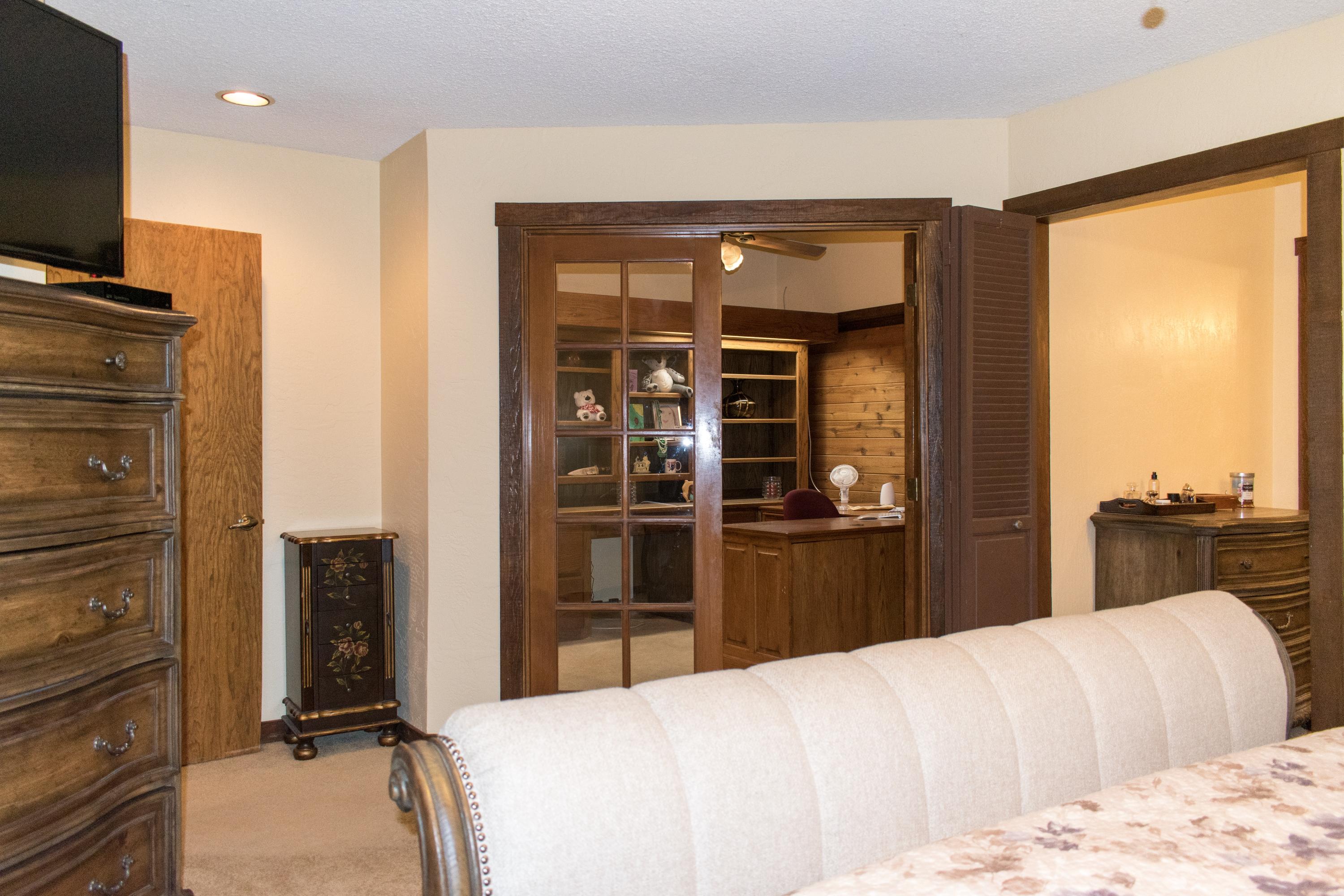 21175 Ridgeway Drive Tehachapi, CA 93561 - Photo 27 of 45 a bedroom with a bed and wooden floor