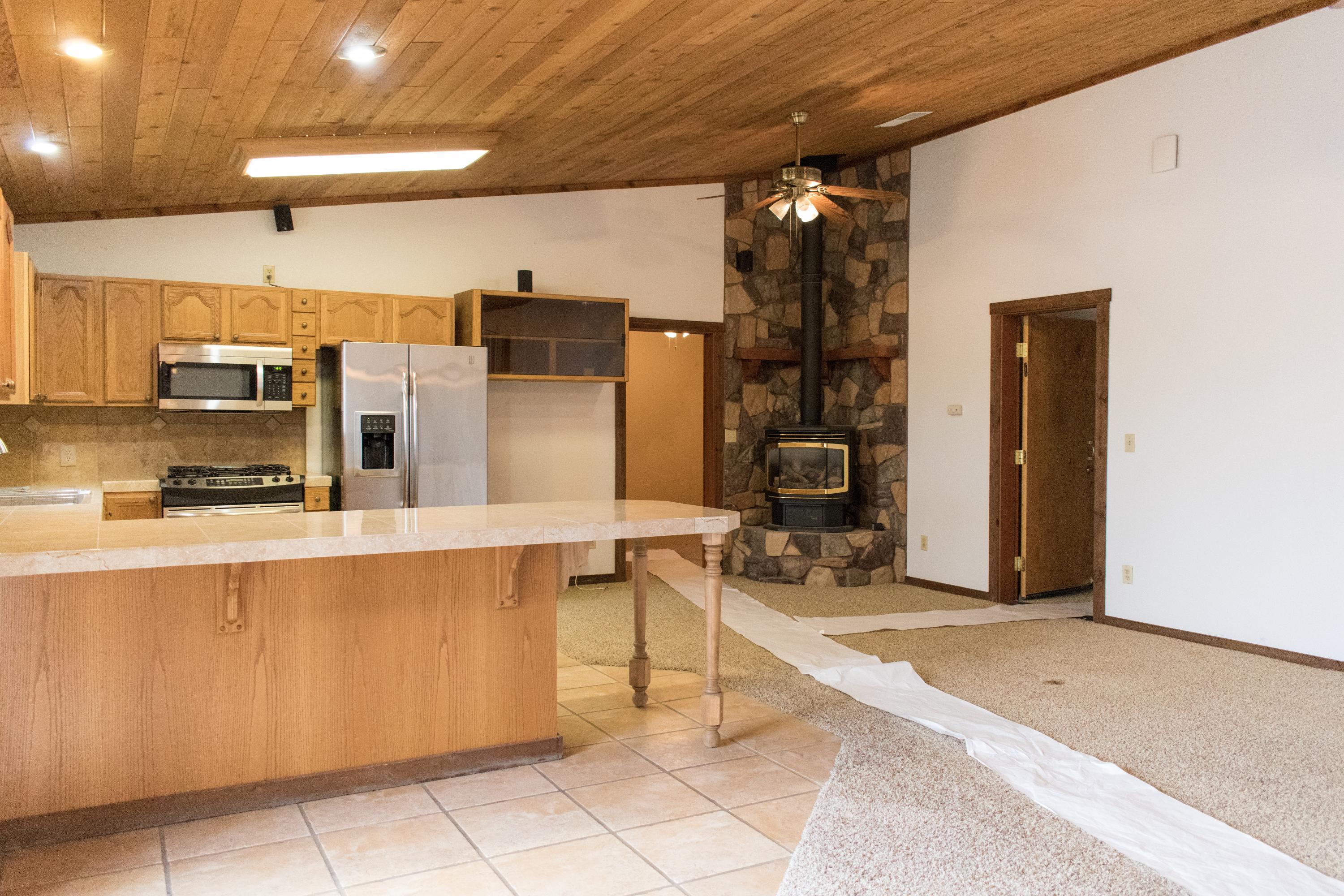 21175 Ridgeway Drive Tehachapi, CA 93561 - Photo 33 of 45 a living room with stainless steel appliances kitchen island granite countertop furniture a rug and a window