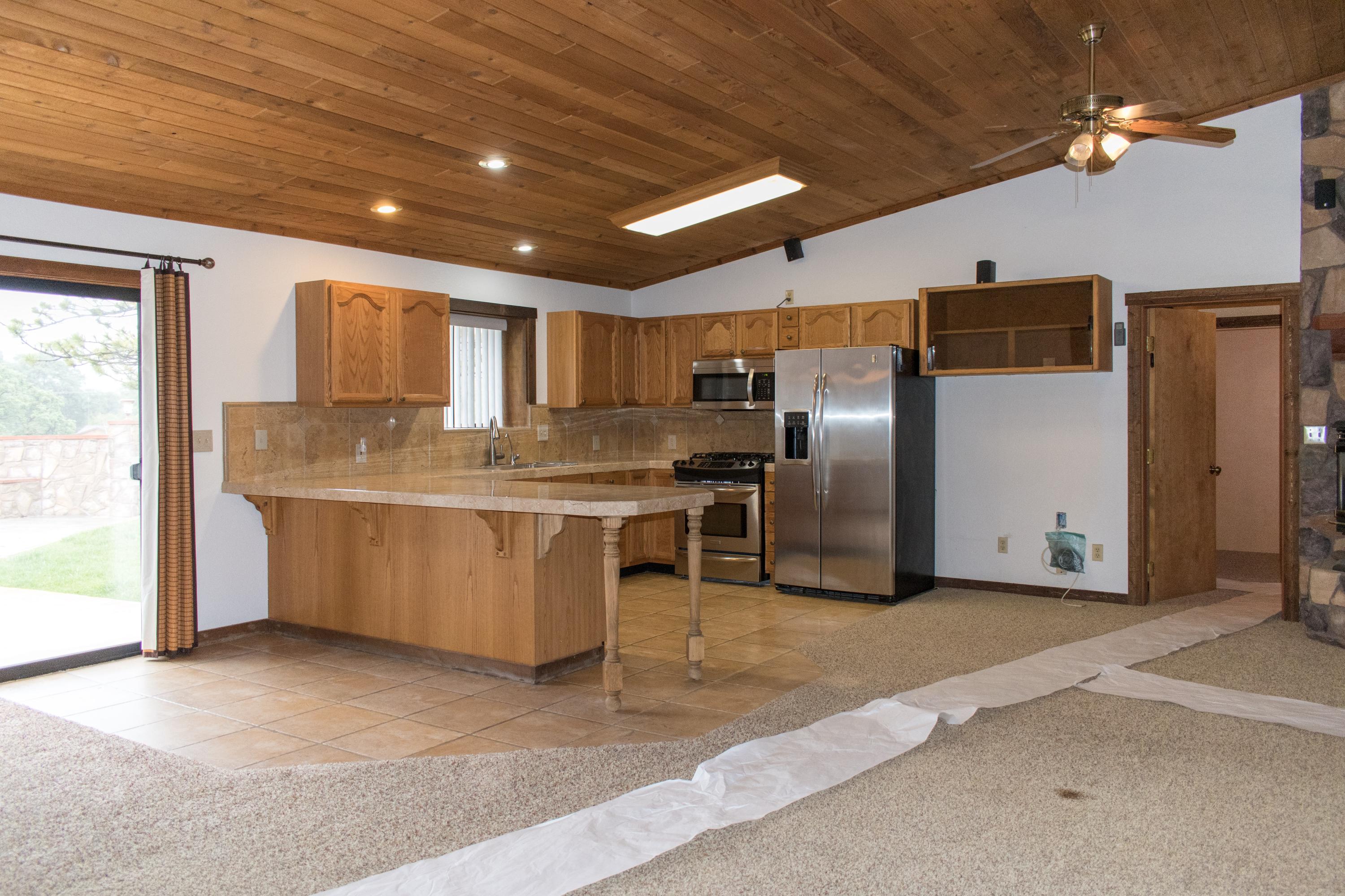 21175 Ridgeway Drive Tehachapi, CA 93561 - Photo 34 of 45 a kitchen with stainless steel appliances granite countertop a refrigerator a sink a stove and a refrigerator with wooden floor