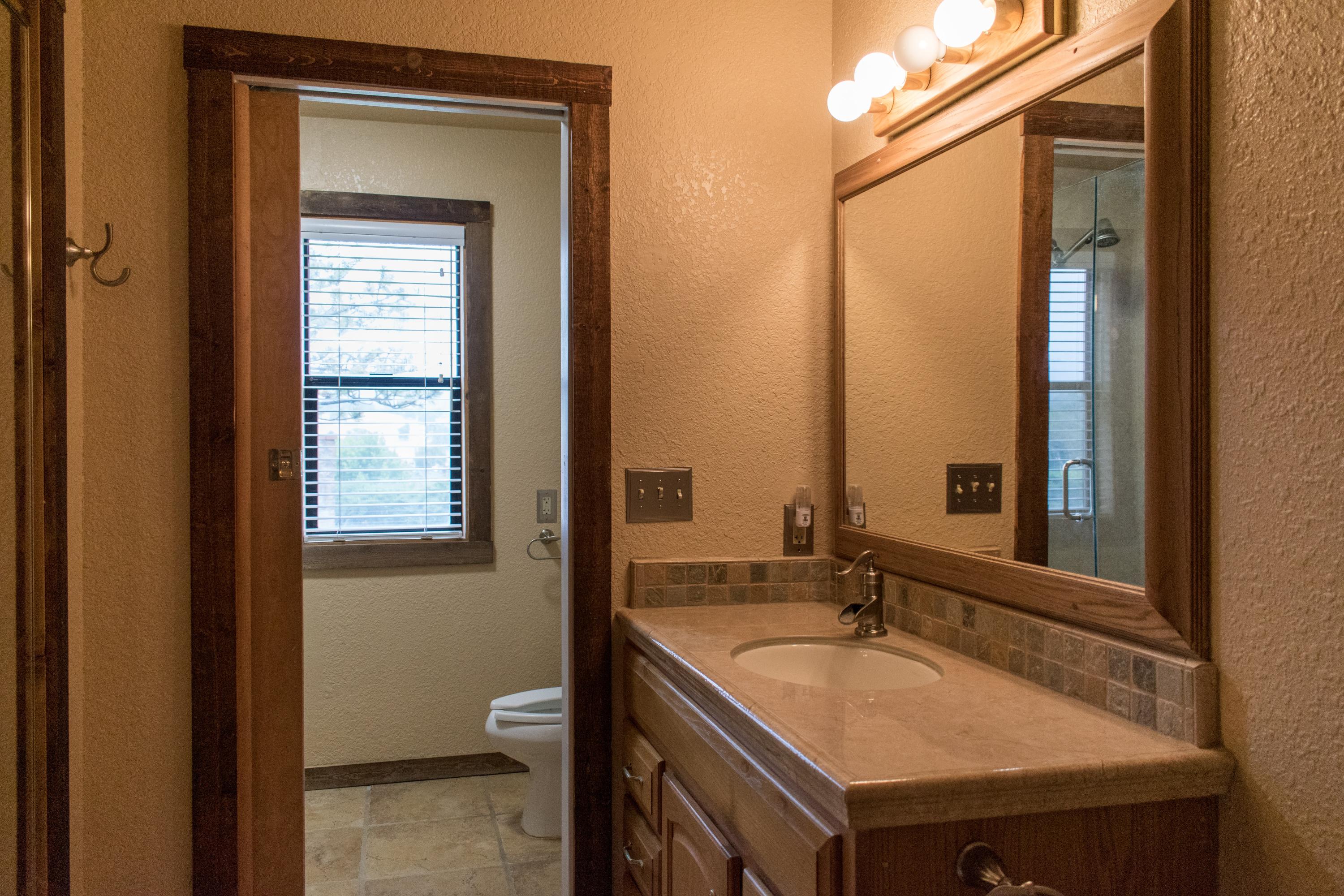 21175 Ridgeway Drive Tehachapi, CA 93561 - Photo 35 of 45 a bathroom with a granite countertop sink and a mirror