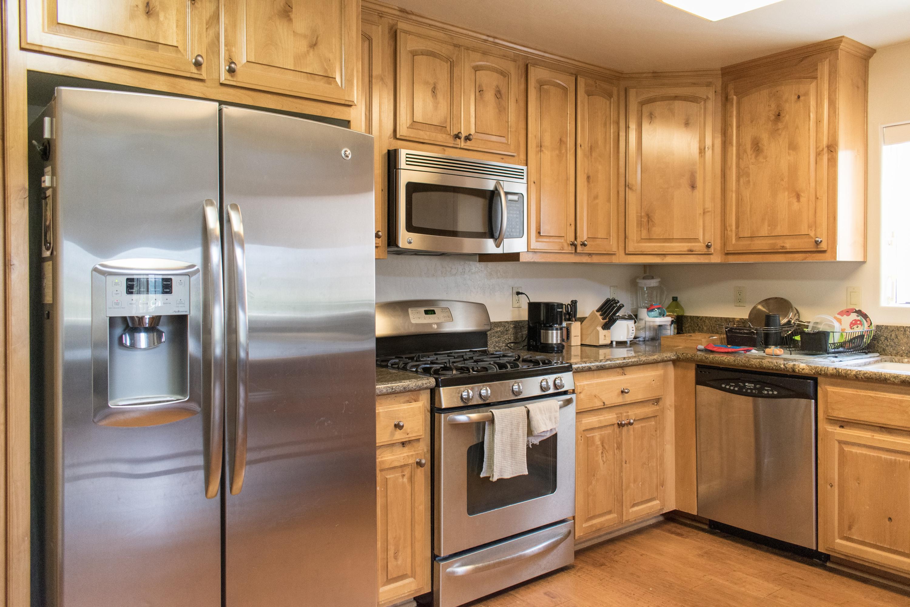 21175 Ridgeway Drive Tehachapi, CA 93561 - Photo 40 of 45 a kitchen with stainless steel appliances granite countertop a stove a refrigerator and a microwave