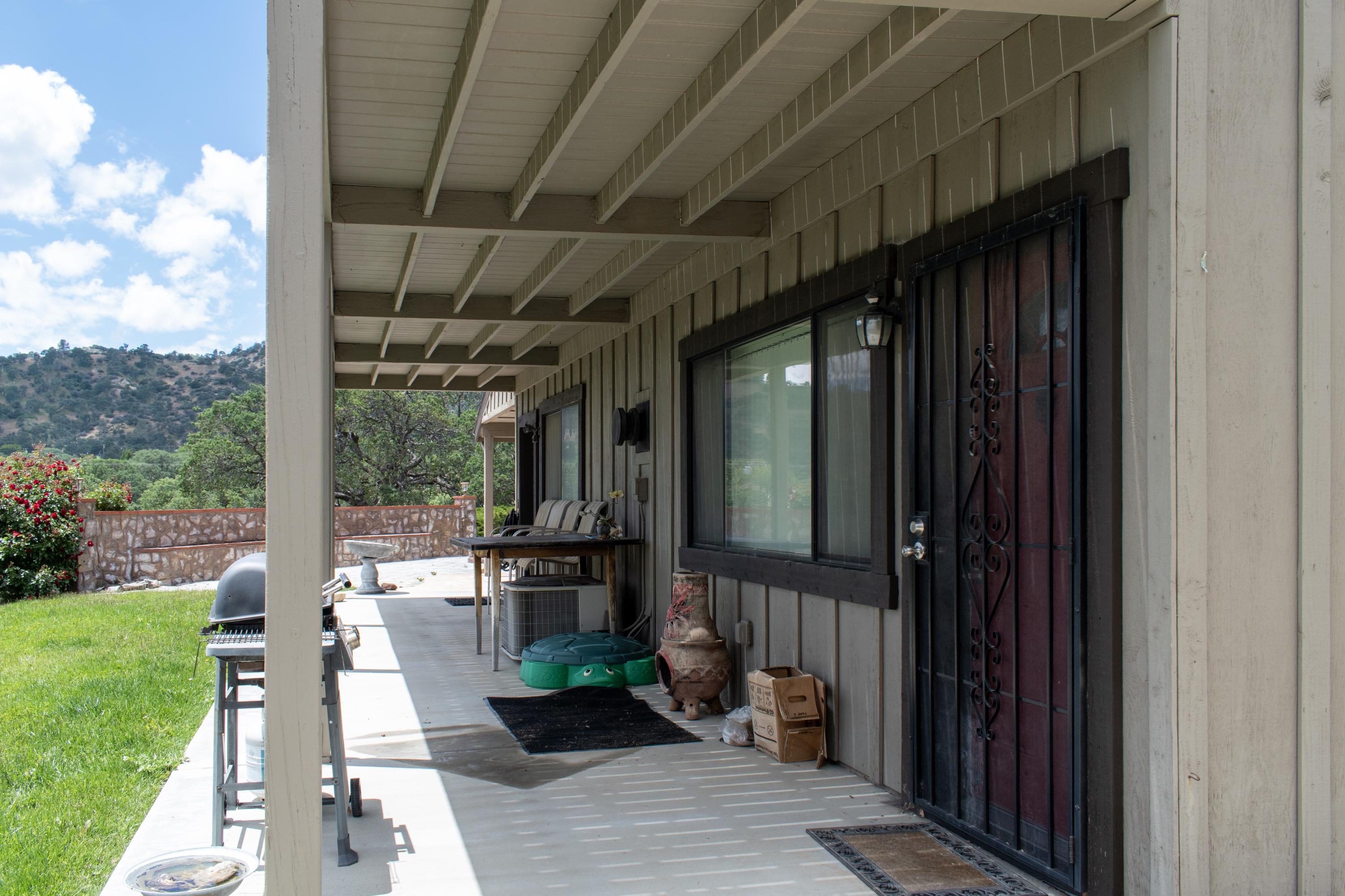 21175 Ridgeway Drive Tehachapi, CA 93561 - Photo 9 of 45 a front view of a house with a garden and patio
