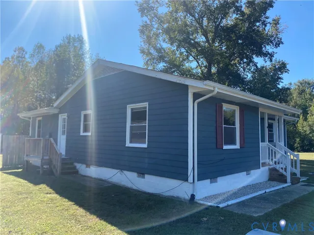 a view of a house with a yard and large tree