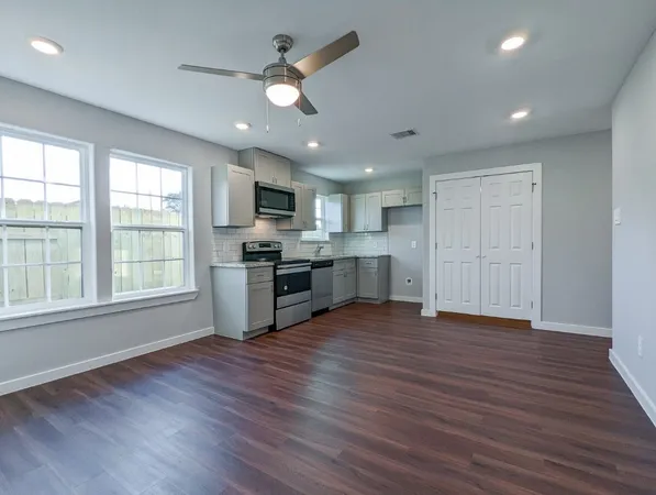 a kitchen with cabinets stainless steel appliances and a sink