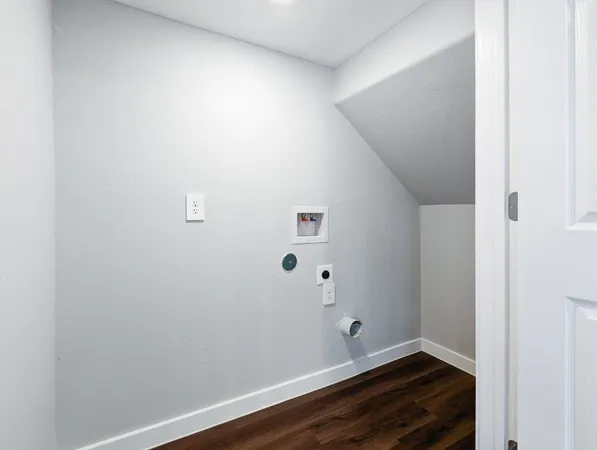 an empty room with wooden floor ceiling fan and windows