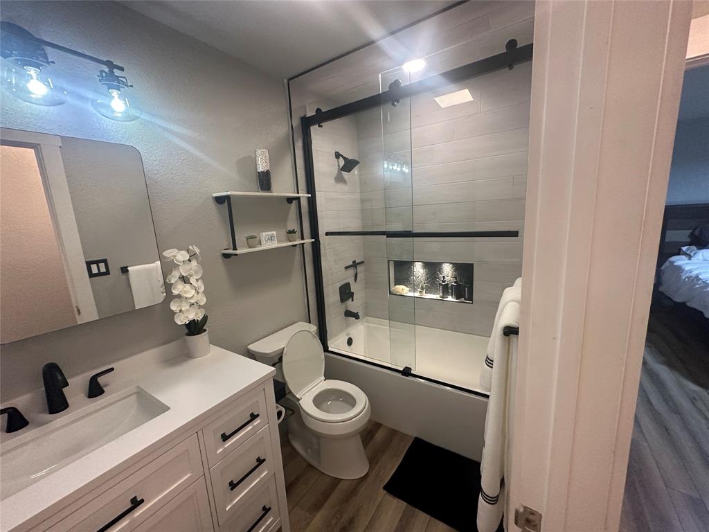 3059 Hells Gate Loop, Unit 8 Strawn, TX 76475 - Photo 22 of 26 a bathroom with a toilet sink and mirror