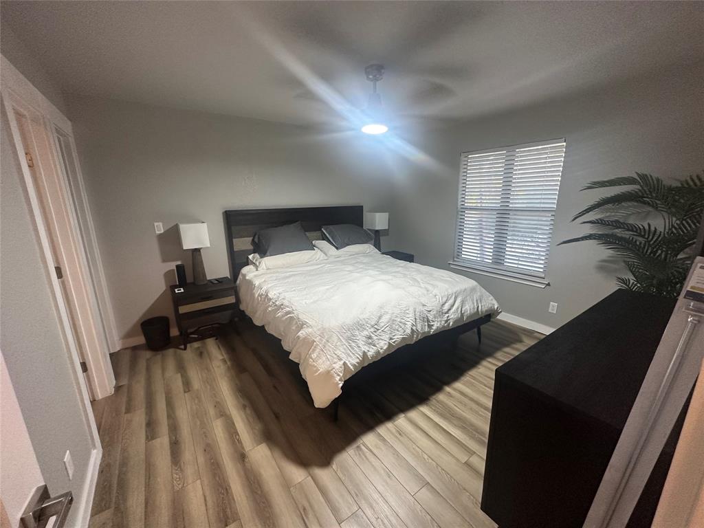 3059 Hells Gate Loop, Unit 8 Strawn, TX 76475 - Photo 24 of 26 a bedroom with a bed and wooden floor