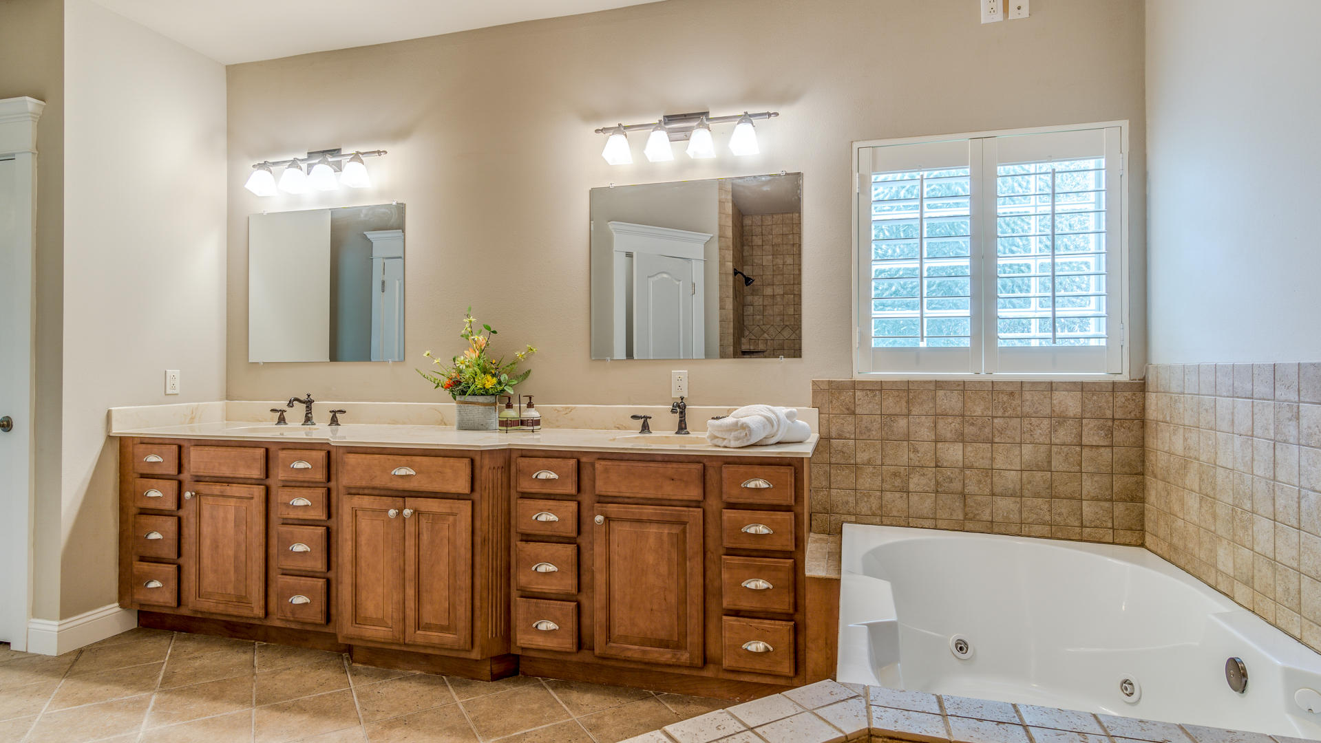 691 Mallet Bayou Road Freeport, FL 32439 - Photo 29 of 49 a bathroom with a tub a double vanity sink and a large mirror
