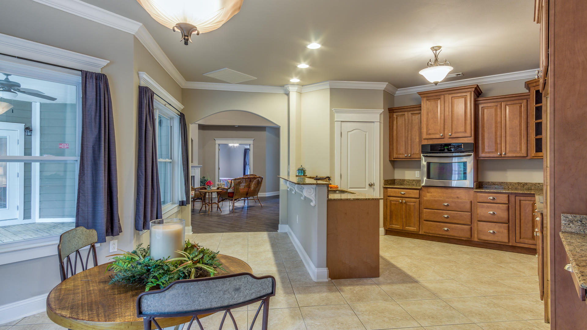 691 Mallet Bayou Road Freeport, FL 32439 - Photo 5 of 49 a large kitchen with kitchen island granite countertop a refrigerator a sink dishwasher a dining table and chairs with wooden floor