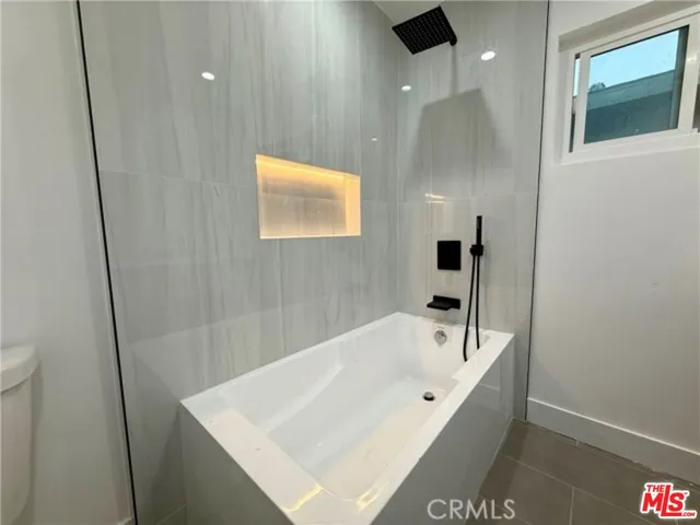 a bath tub sitting next to a white toilet and a sink