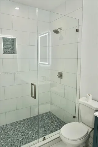 a bathroom with a toilet and a shower