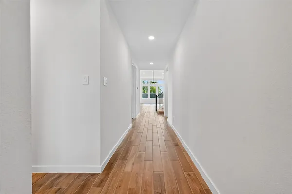 a view of a hallway with wooden floor