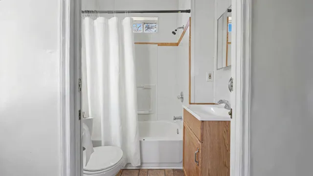 a bathroom with a sink a toilet and shower curtain