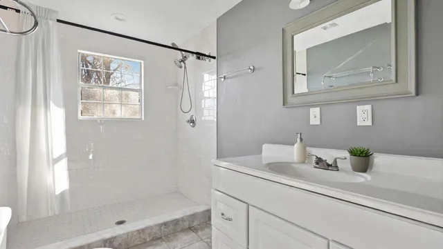 a bathroom with a shower sink and mirror