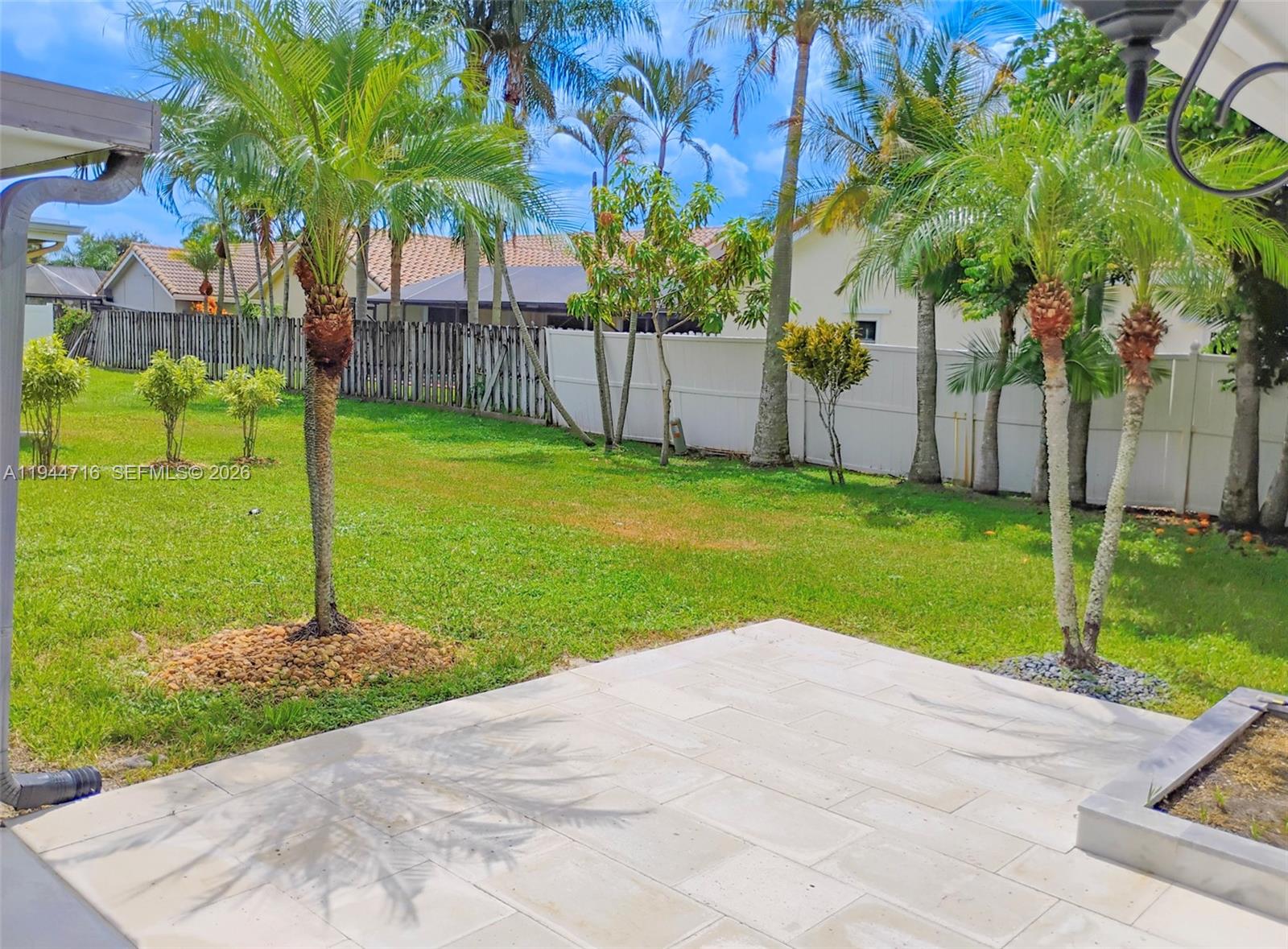 9654 Sun Pointe Drive Boynton Beach, FL 33437 - Photo 12 of 52 a garden with trees in front of it