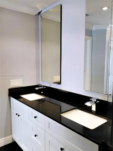 a bathroom with a granite countertop sink a mirror and shower