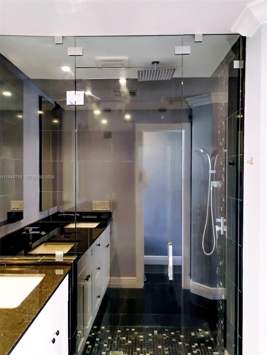 9654 Sun Pointe Drive Boynton Beach, FL 33437 - Photo 32 of 52 a bathroom with a granite countertop sink a mirror and shower