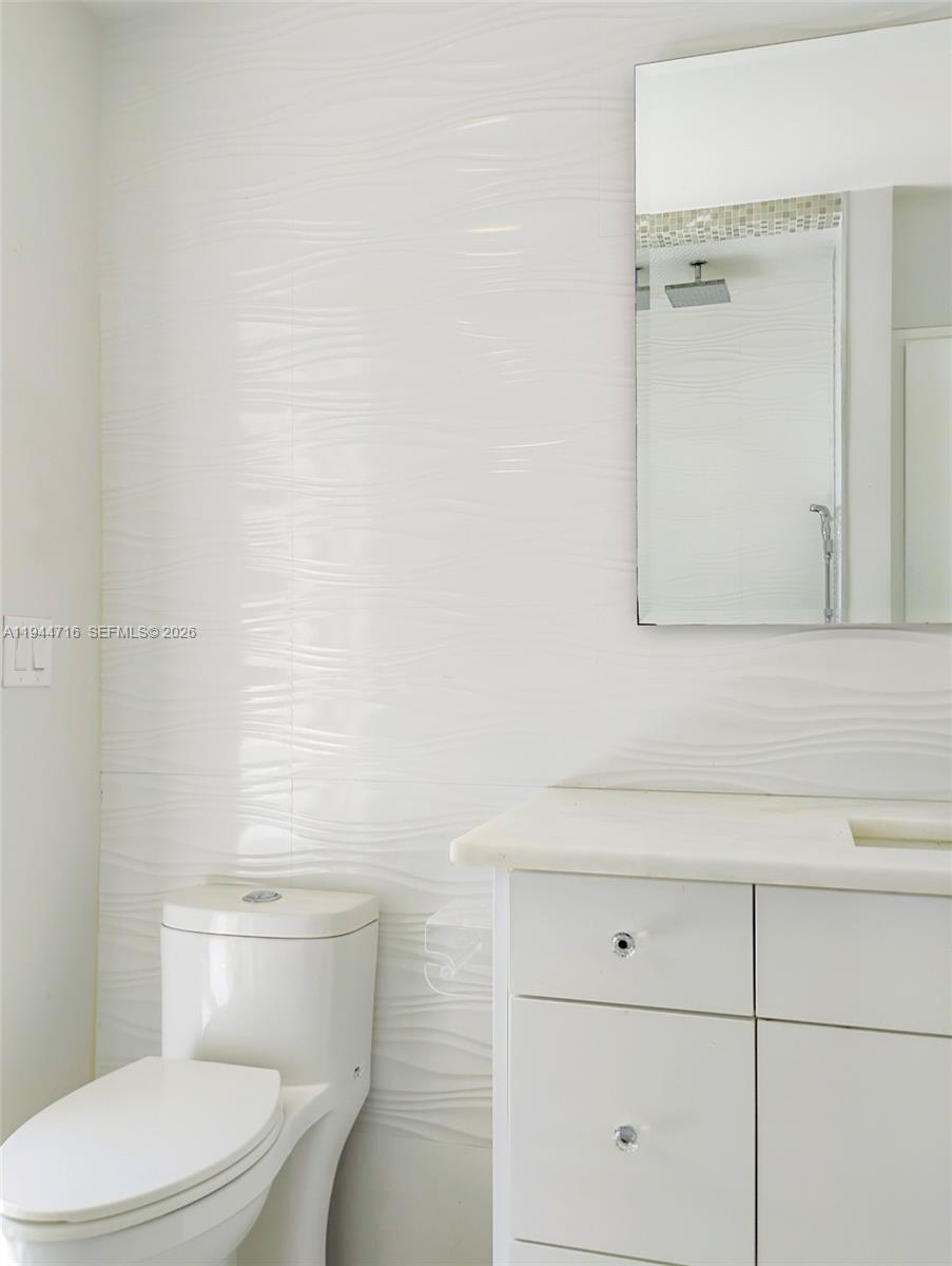 9654 Sun Pointe Drive Boynton Beach, FL 33437 - Photo 37 of 52 a white toilet sitting next to a bathroom sink